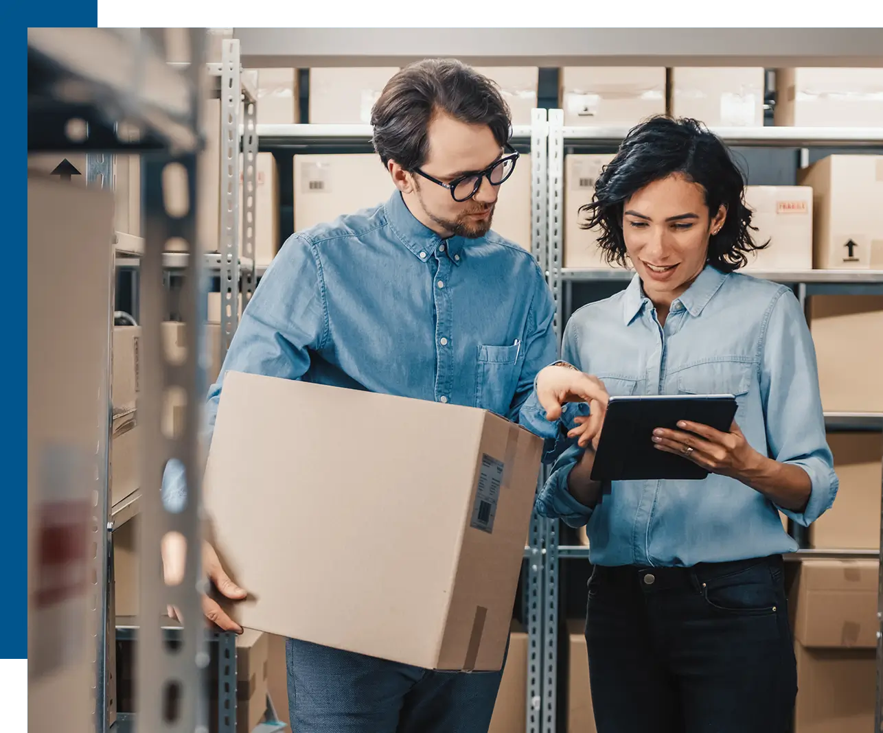 Two people in a warehouse looking at an ipad.