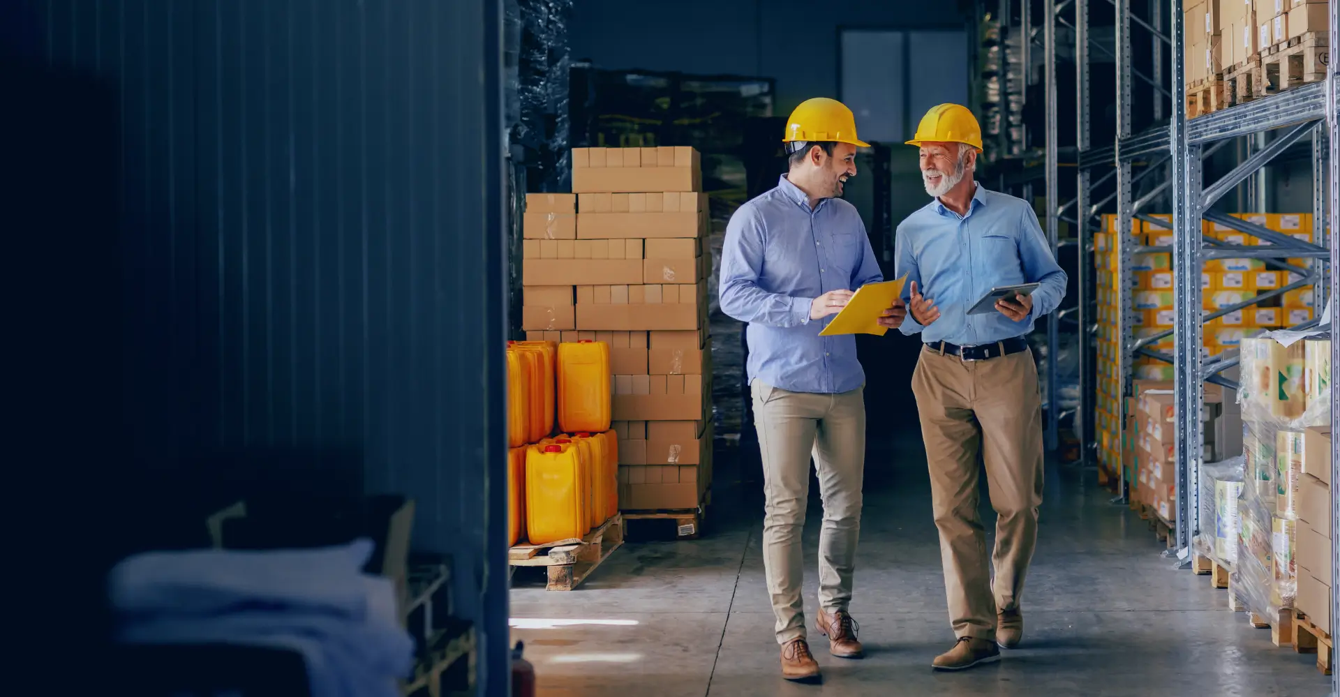 Two men in hard hats are talking to each other.